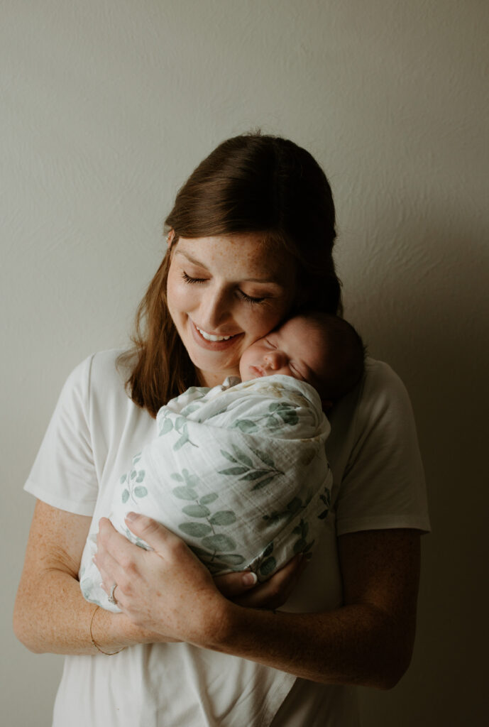 mom holding her newborn baby smiling