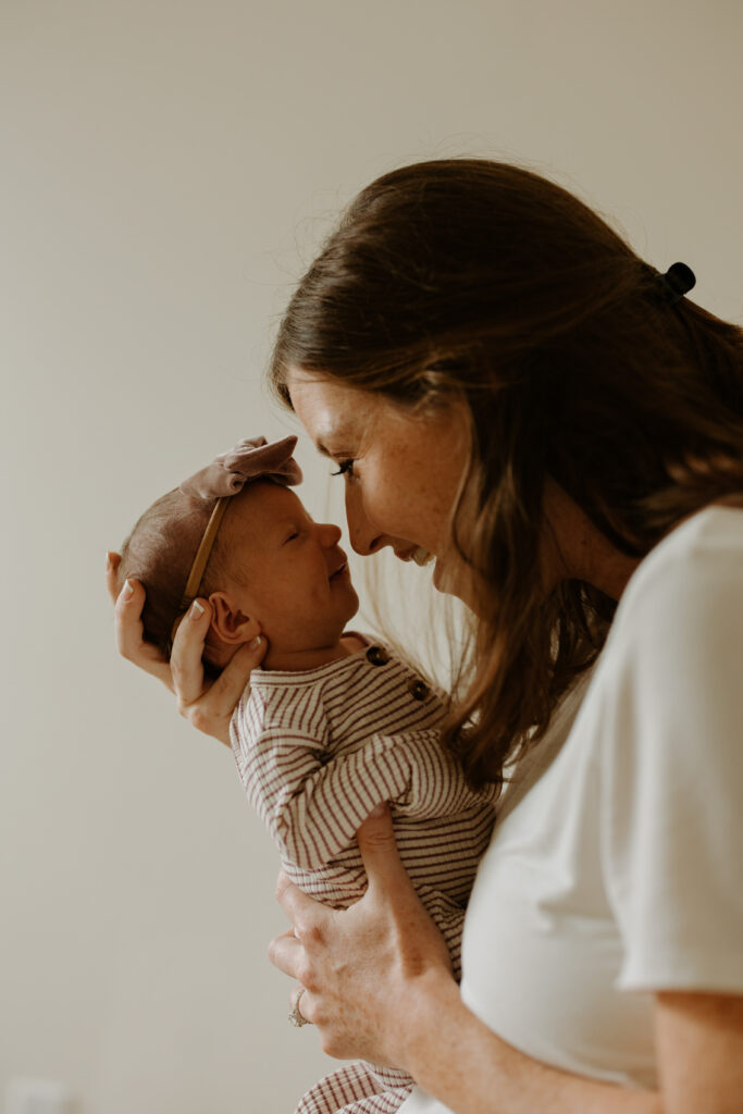 mother holding her newborn child, smiling at eachother