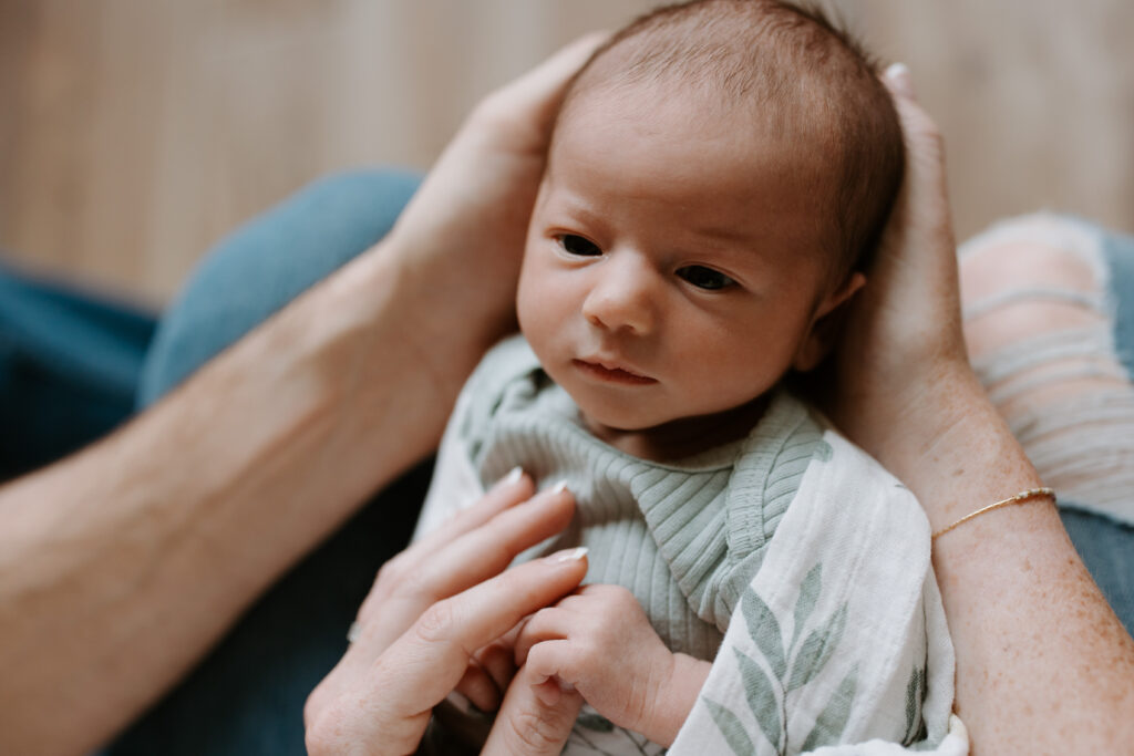 newborn baby holding mom's hand